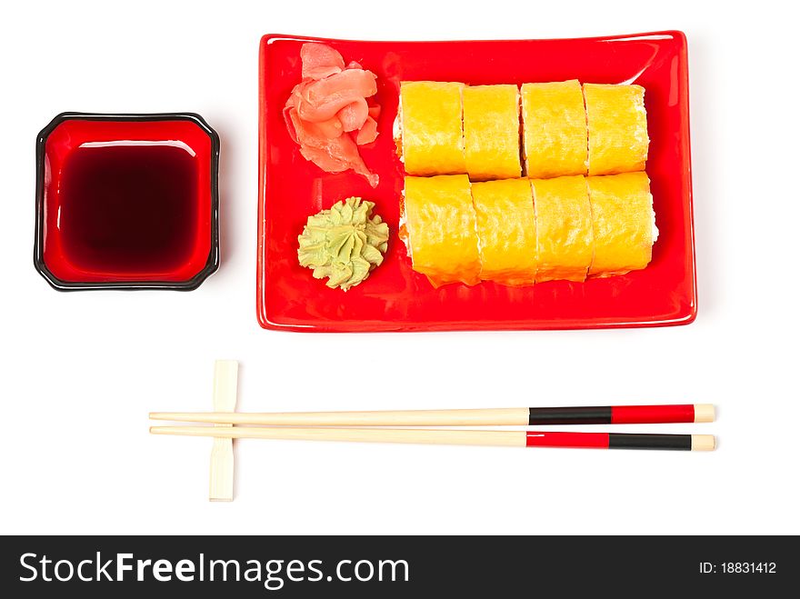 Yellow sushi rolls served on a plate. White background