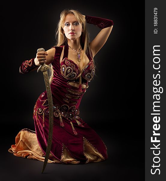 Beauty arabian dancer sit with saber