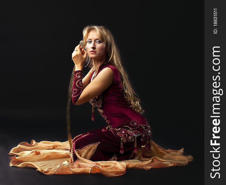 Beauty Woman In Arabian Costume Sit With Saber