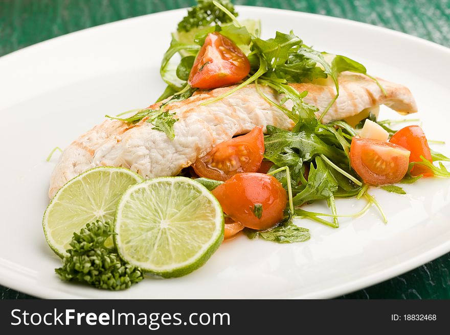 Photo of grilled chicken breast with fresh green rocket salad. Photo of grilled chicken breast with fresh green rocket salad