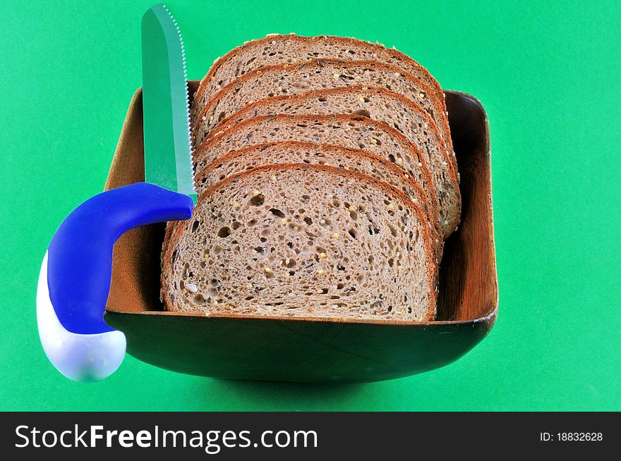 Black rye bread cut into slices lying in a wooden platter. Black rye bread cut into slices lying in a wooden platter