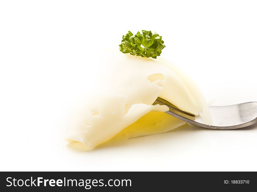 Photo of fork with thin slice of cheese with parsley. Photo of fork with thin slice of cheese with parsley