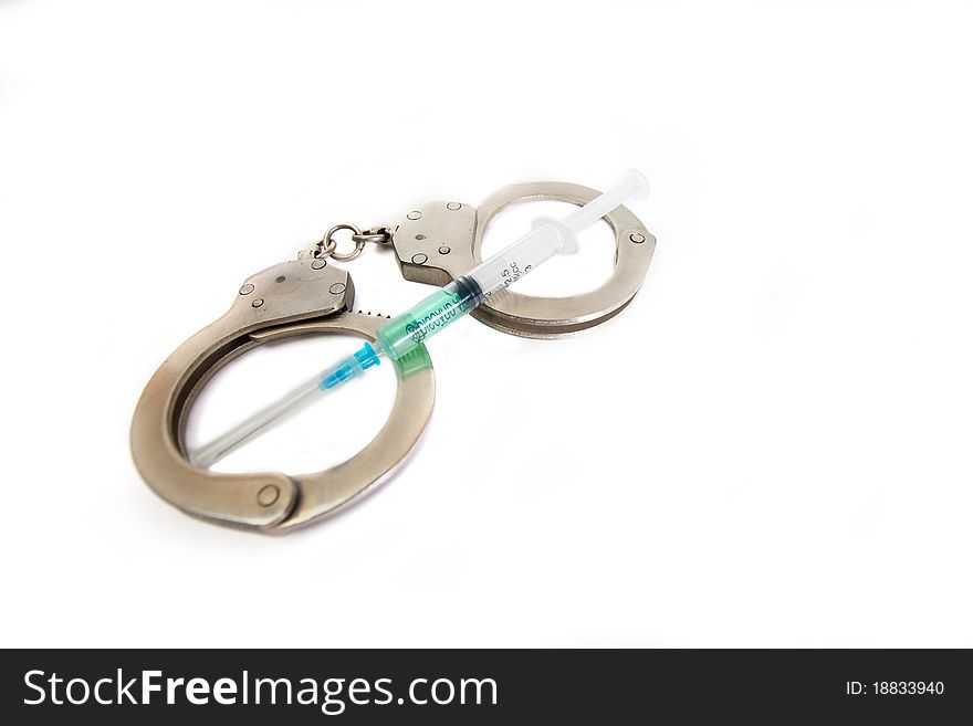 The compressed handcuffs and syringe on a white background