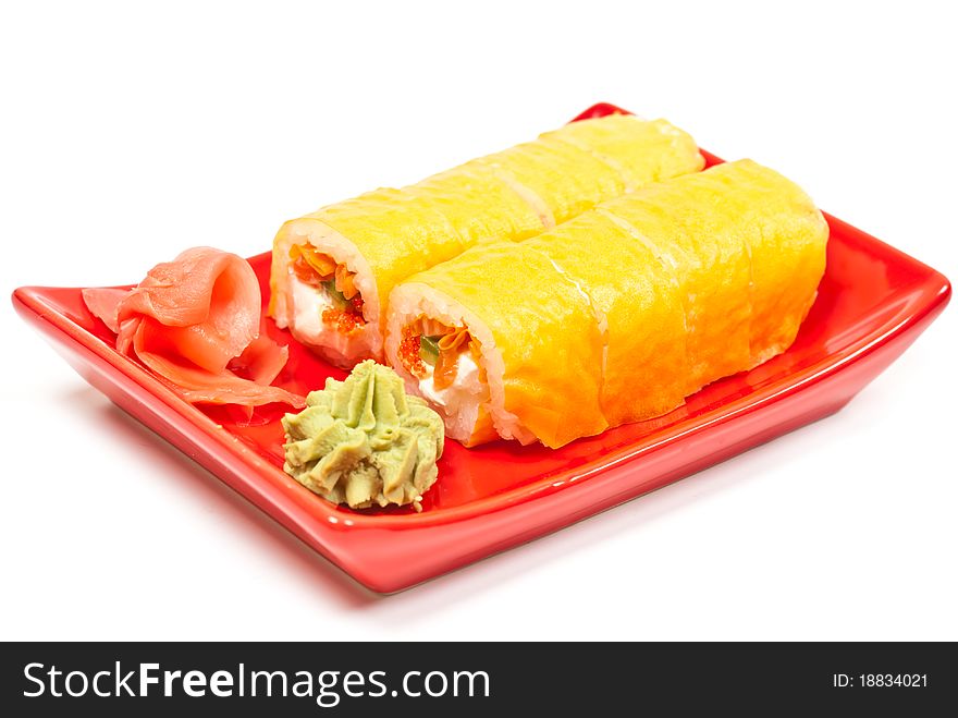 Yellow sushi rolls served on a plate. White background