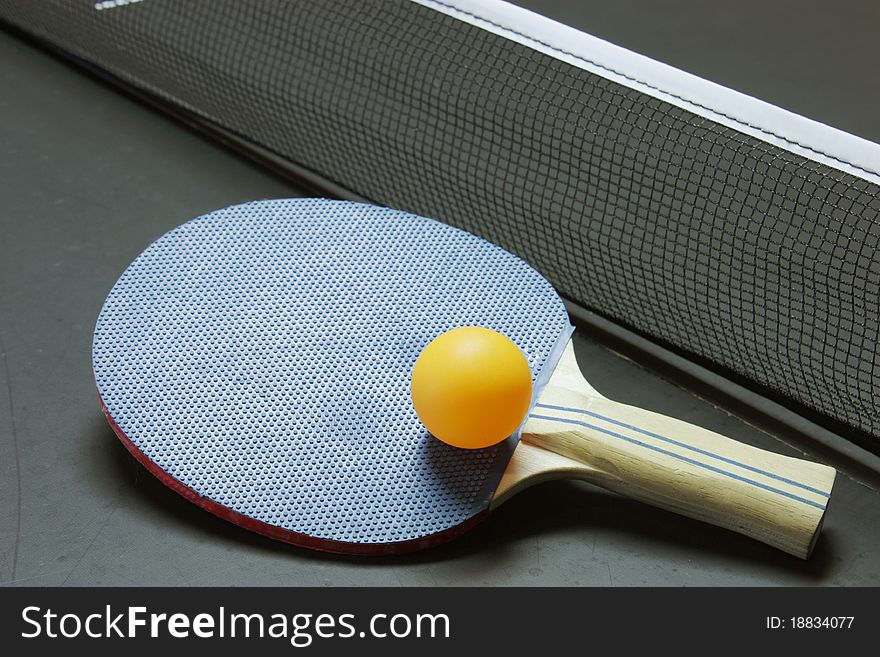 Ping pong paddle, ball and table all ready for a game