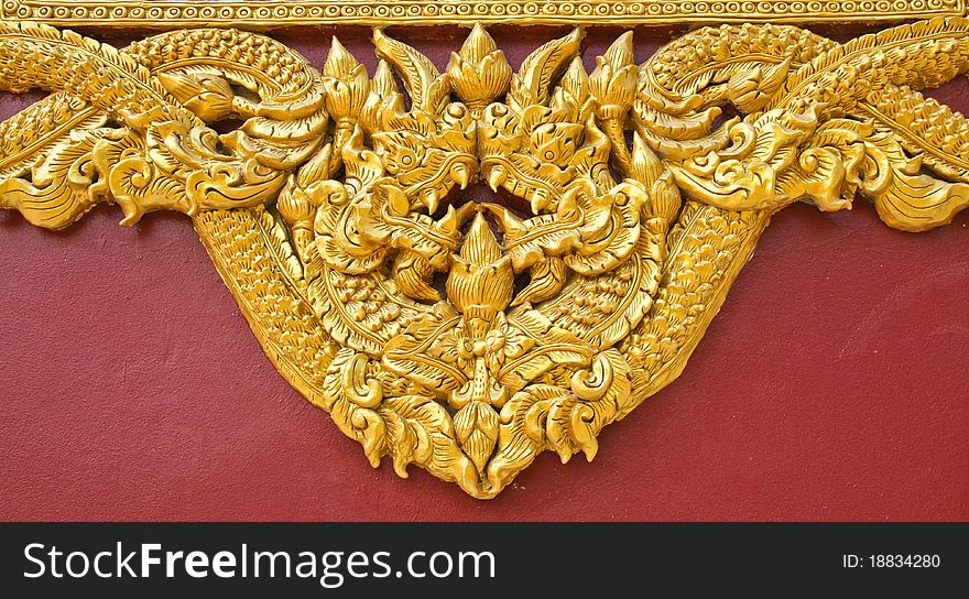 High relief sculpture, gold serpent on the floor of the temple wall. In northern Thailand