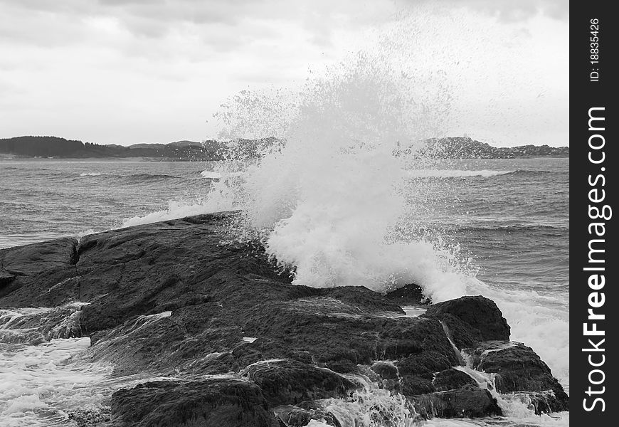 Sea wave breaking against coast rock