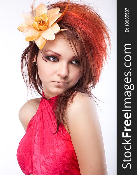 Portrait of beautiful woman with spring flower in hair on white