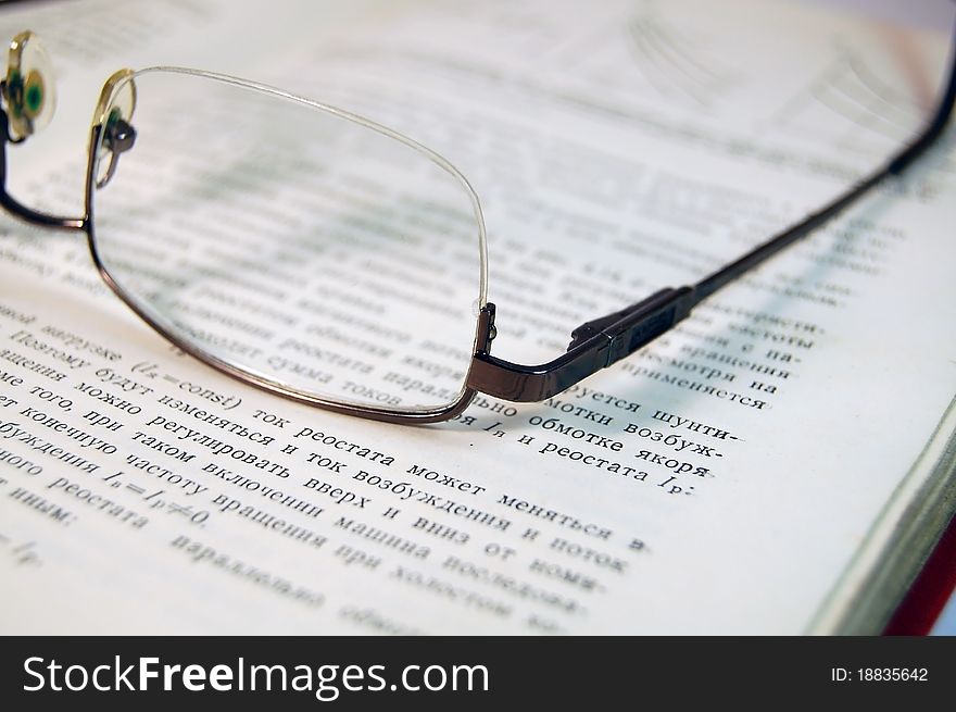 Glasses lie on a book with the text close. Glasses lie on a book with the text close