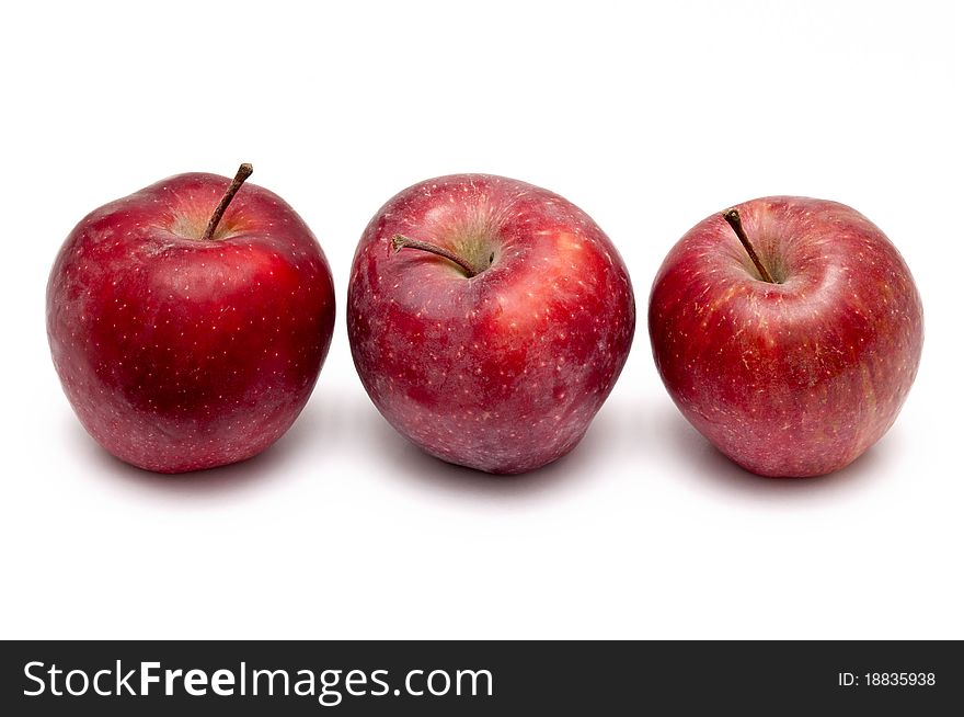 Three red apples over white background