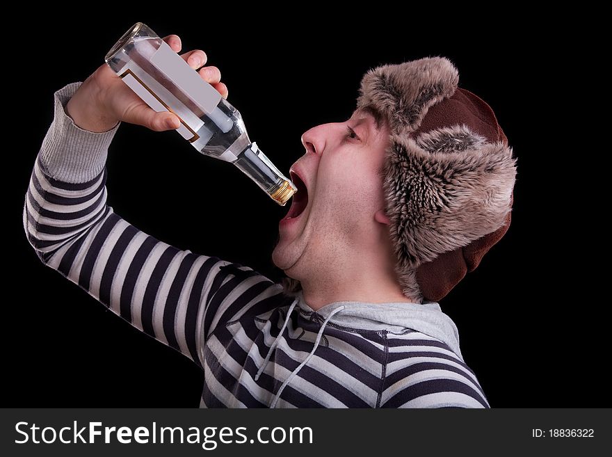 Man in a striped sweater and a fur hat with the bottle of alkohol