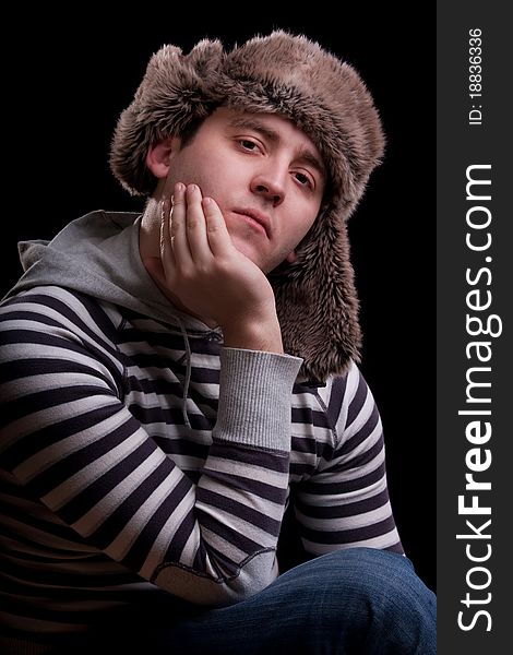Portrait of man in a striped sweater and a fur hat. Portrait of man in a striped sweater and a fur hat