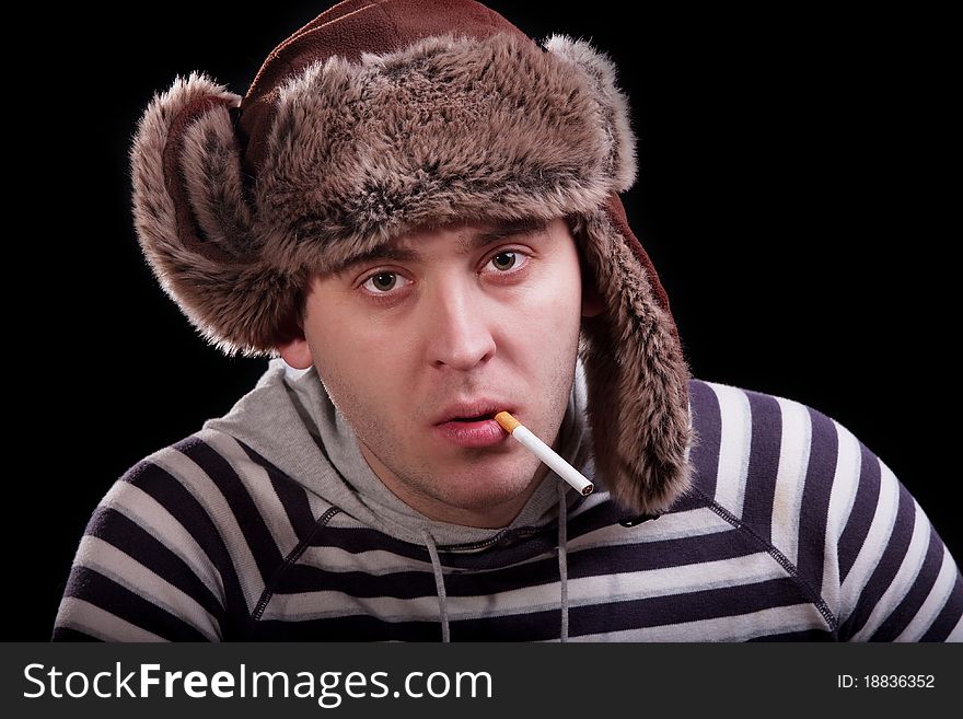 Emotional portrait of a man in a striped sweater and a fur hat