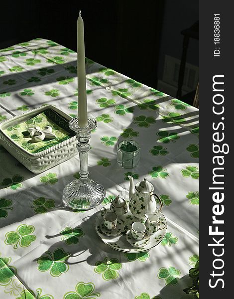Table set for St. Patrick's Day, with shamrock tablecloth, tea set, napkins, candle. Table set for St. Patrick's Day, with shamrock tablecloth, tea set, napkins, candle.