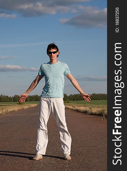 Young man standing alone outdoors. Young man standing alone outdoors