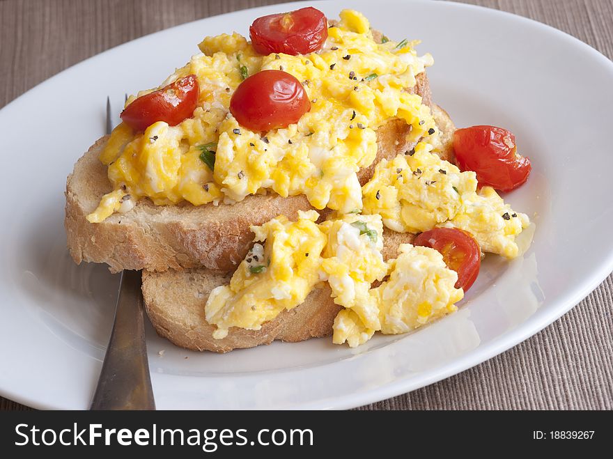 Toast with scrambled eggs and cherry tomatoes. Toast with scrambled eggs and cherry tomatoes