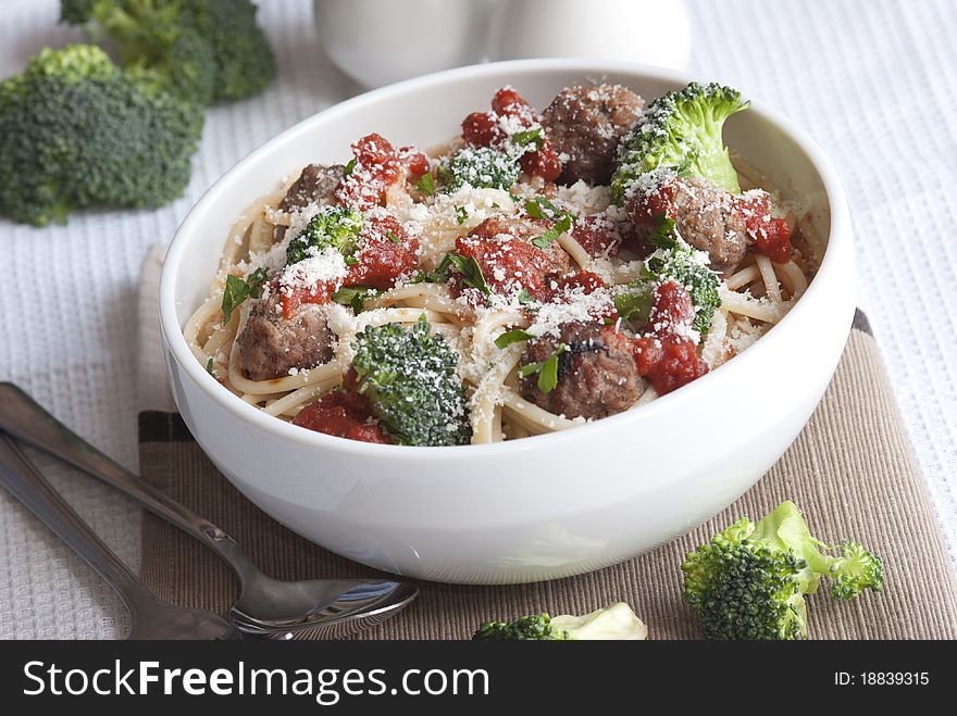 Beef meatballs with spaghetti and broccoli topped with grated parmesan. Beef meatballs with spaghetti and broccoli topped with grated parmesan