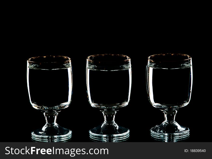 Three wine glasses with alcohol. Black background. Studio shot.