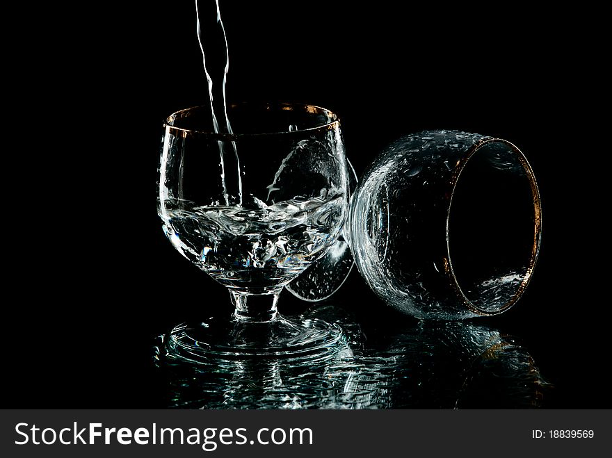 Two wine glasses with drops of water on it. Black background. Studio shot. Two wine glasses with drops of water on it. Black background. Studio shot.