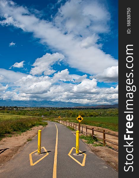 A paved bike trail in Riverside,CA with clouds and blue sky.