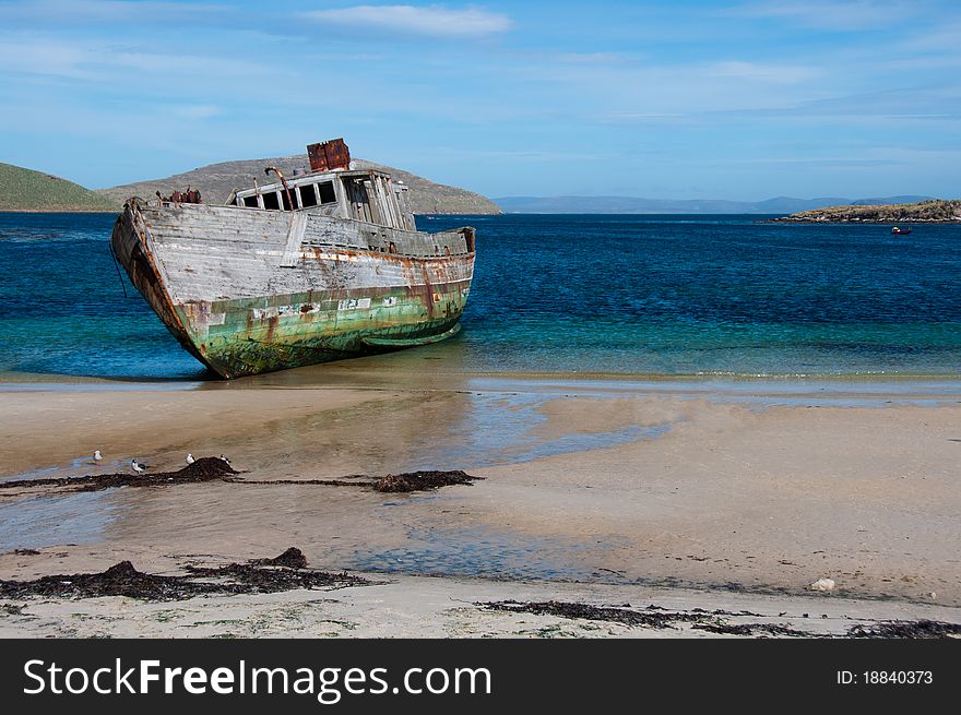 An old shipwreck washed up on the beach along the coastline of the Shetland Islands, Antarctica. An old shipwreck washed up on the beach along the coastline of the Shetland Islands, Antarctica