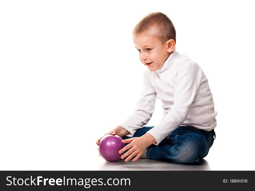 Cute little boy playing with a ball isolated on white
