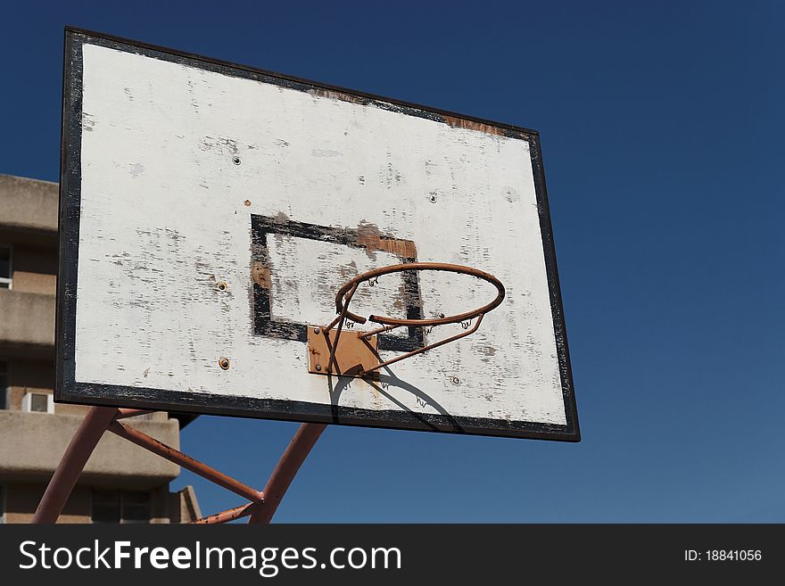 Old broken basketball hoop against the sky