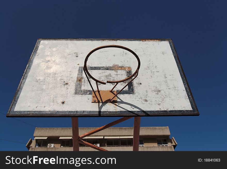 Old broken basketball hoop against the sky