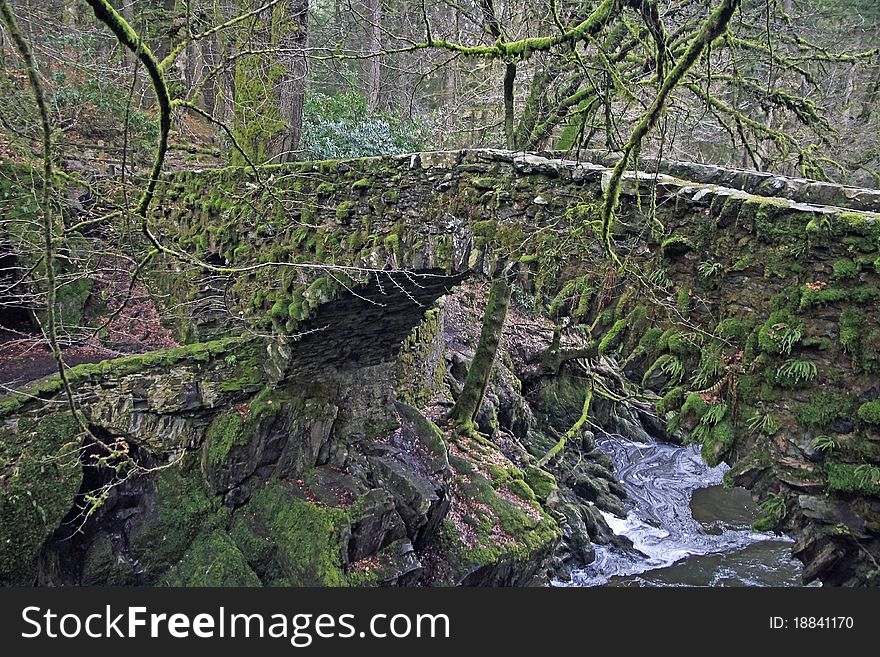 Stone bridge over waterfall in the highlands of scotland in winter
