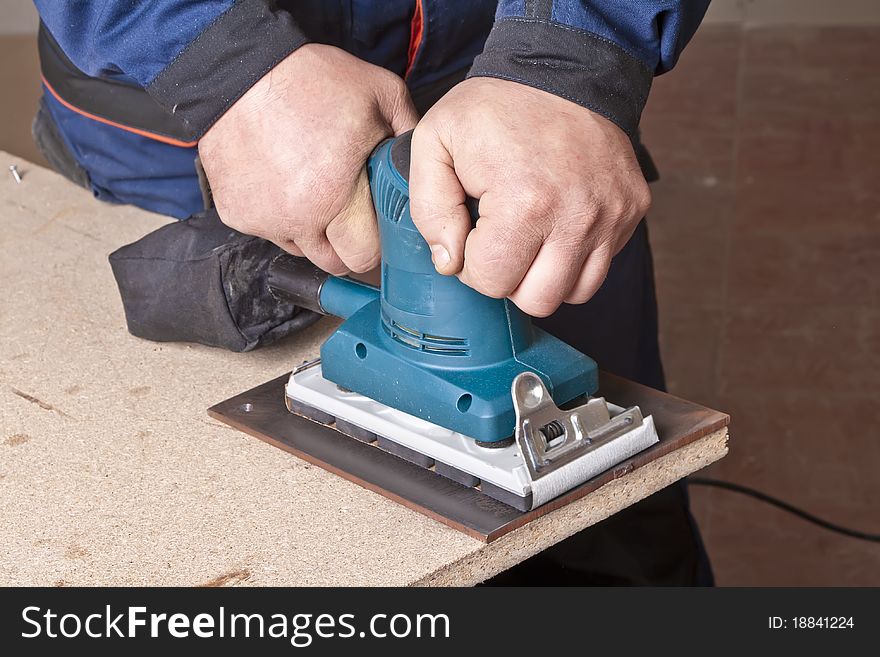 A man working with electrical sanding machine, close up on tool, hands and sparks, real situation picture. A man working with electrical sanding machine, close up on tool, hands and sparks, real situation picture