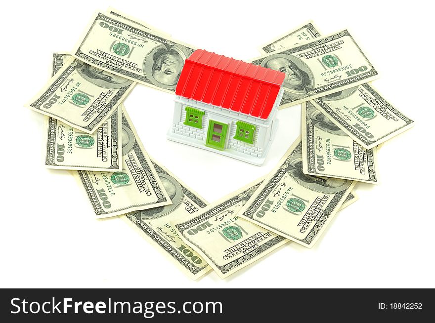 Toy house with hundreds dollars around it, over white background. Toy house with hundreds dollars around it, over white background