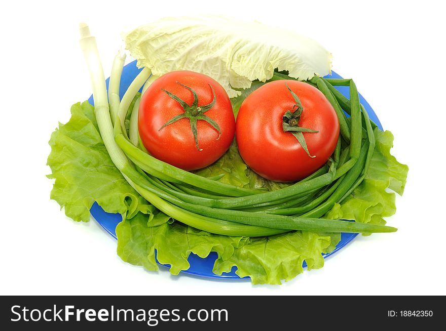 Vegetables on blue plate, isolated on a white background. Vegetables on blue plate, isolated on a white background