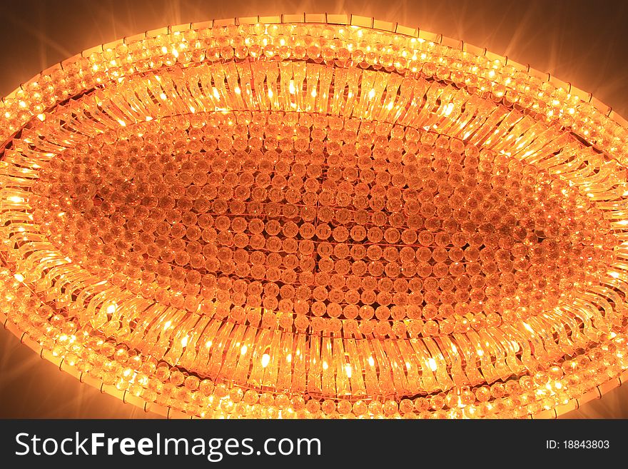 A crystal chandelier at ceiling.Image was taken in a meeting room.