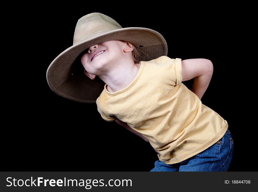 A cute girl with an oversized hat on her head. It is pulled over her eyes. A cute girl with an oversized hat on her head. It is pulled over her eyes.