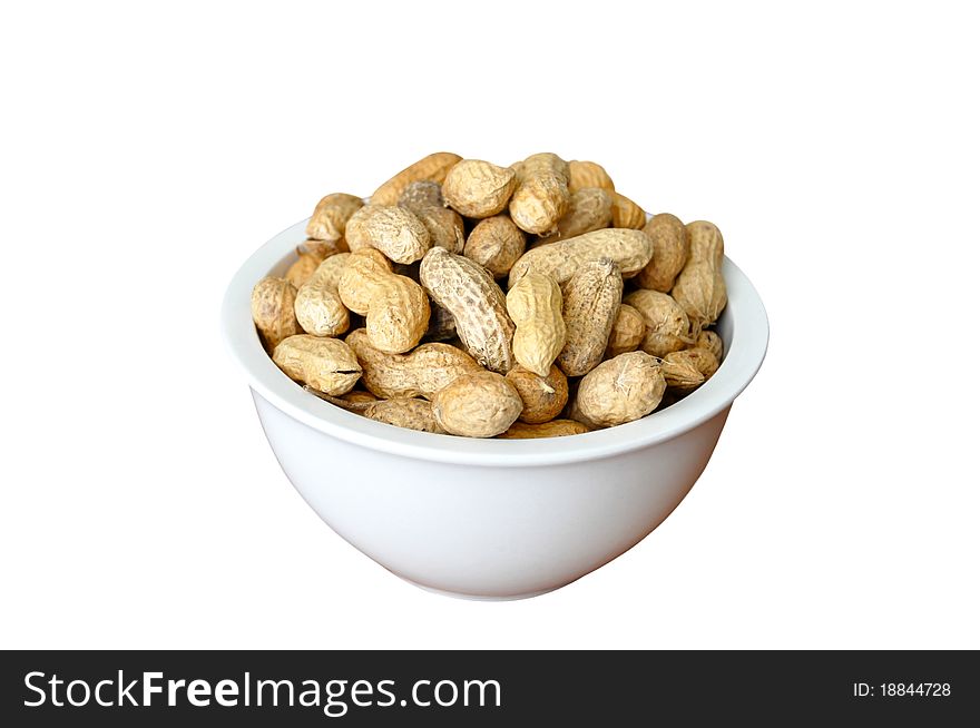 A white dish full of peanuts in nutshell