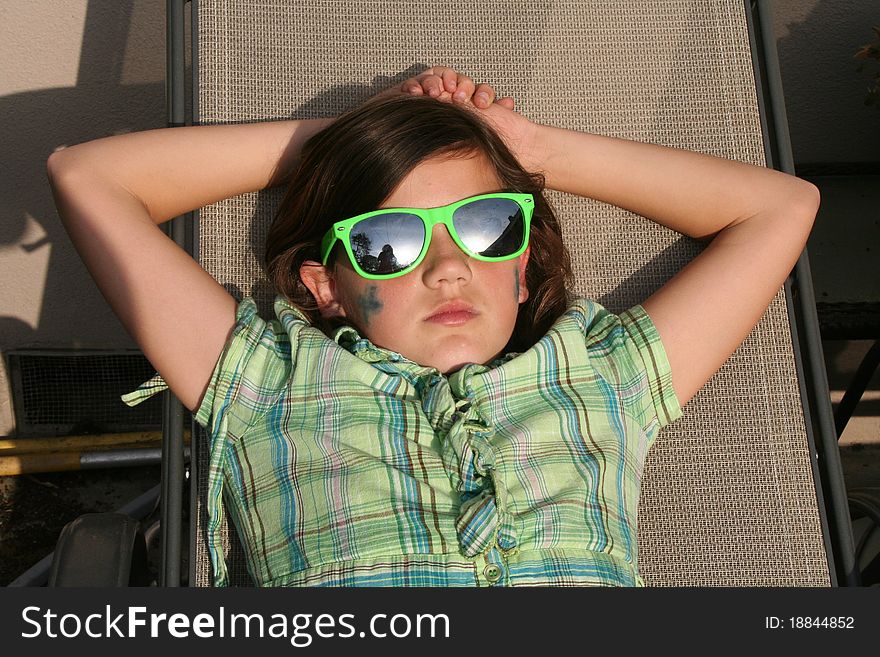 Girl lounging outdoors in a chair.