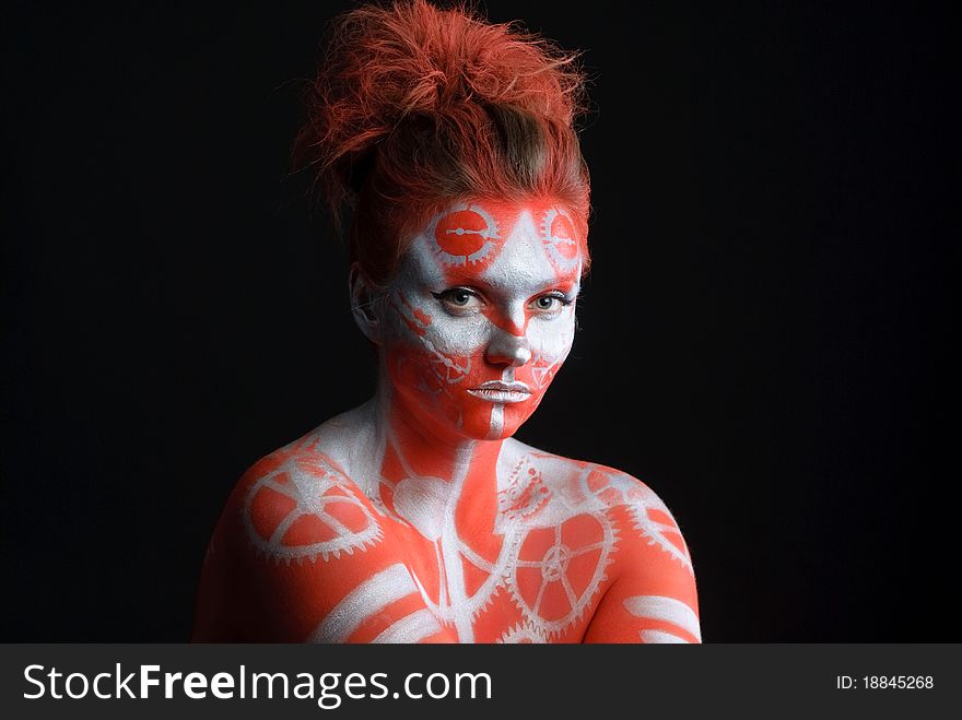 Mystic young woman with painted face looking at camera