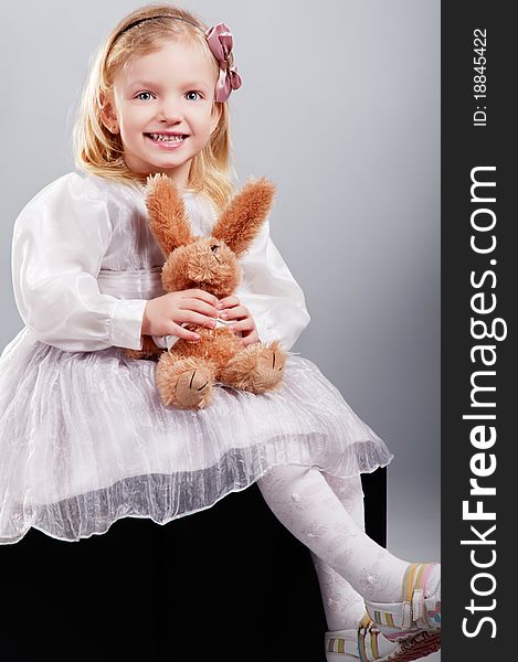 Little Girl Hugging Bear Toy And Smiling
