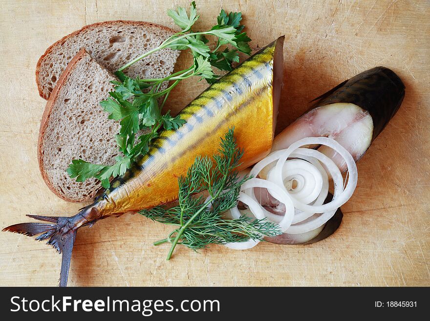 Sliced bloated fish and bread on wooden surface