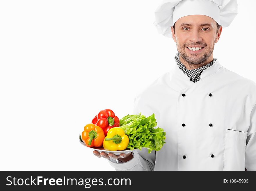 Attractive chef with a plate with vegetables on white background. Attractive chef with a plate with vegetables on white background