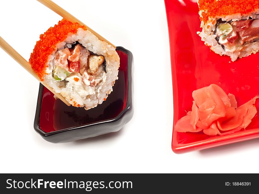 Sushi rolls served in chopsticks . White background