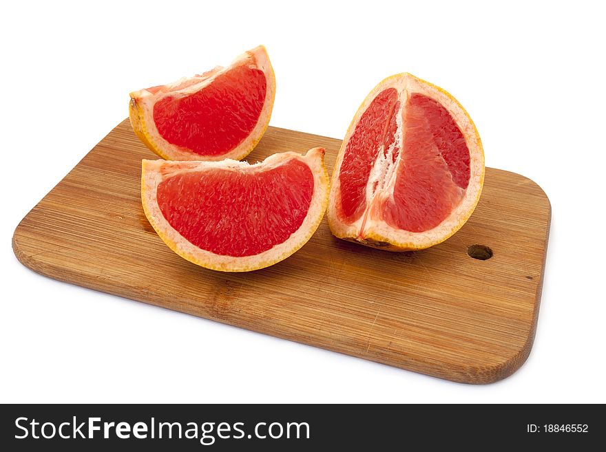 Grapefruit slices on a cutting board over white background