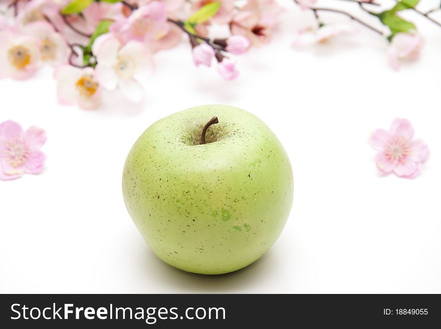 Green apple with flowering branch