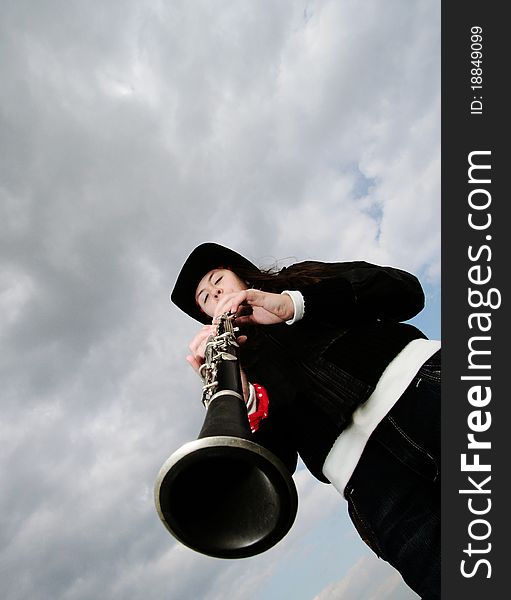 Girl playing on clarinet. Wide angle lens. Girl playing on clarinet. Wide angle lens.