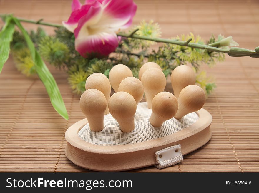 Massage brush and bunch of flowers on mat