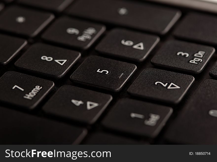 Black notebook keyboard with focus on a numeric part, closeup. Black notebook keyboard with focus on a numeric part, closeup