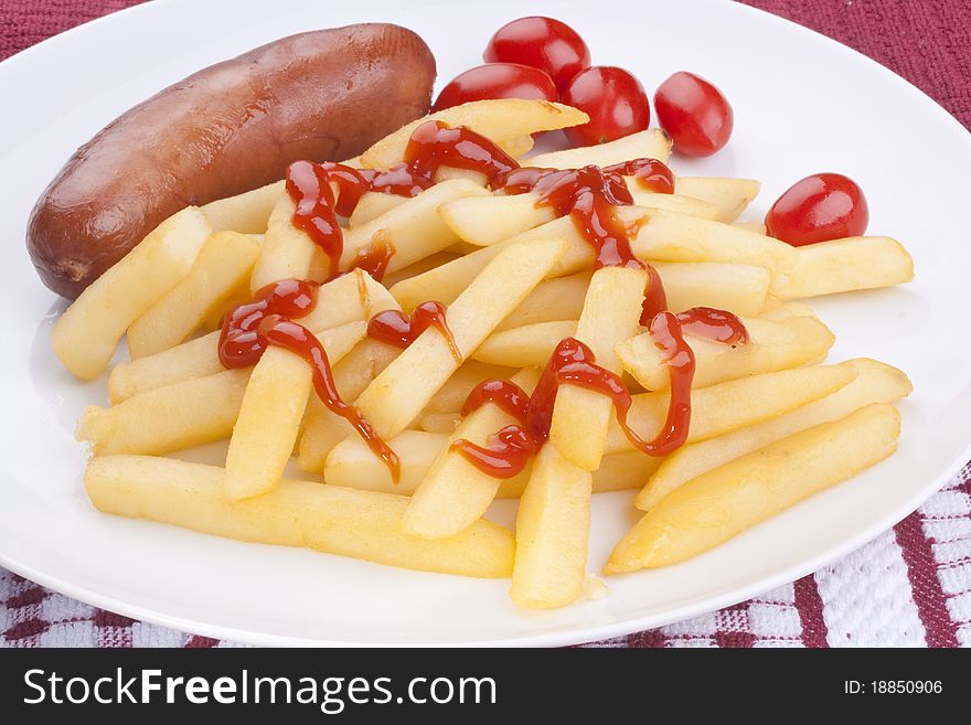 The fried potato is watered by ketchup with sausage and tomatoes.