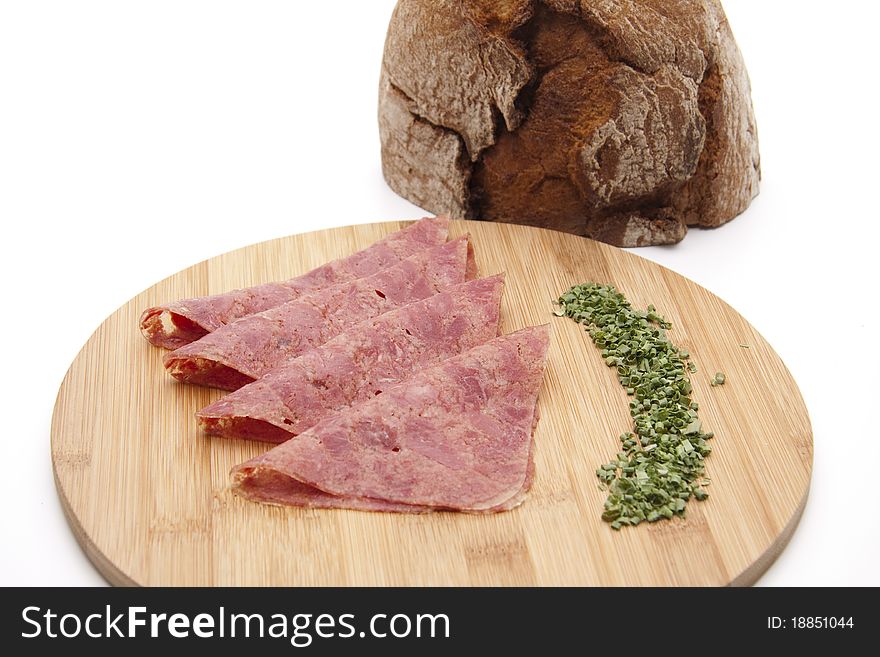 Corned beef with chives and bread onto wood plates. Corned beef with chives and bread onto wood plates