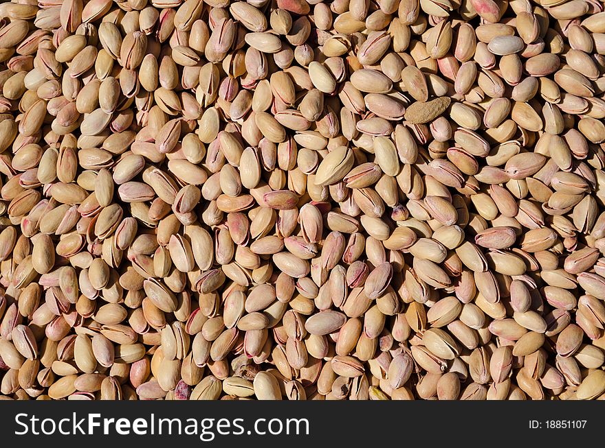 Bunch of salted roasted pistachios with salt in the market