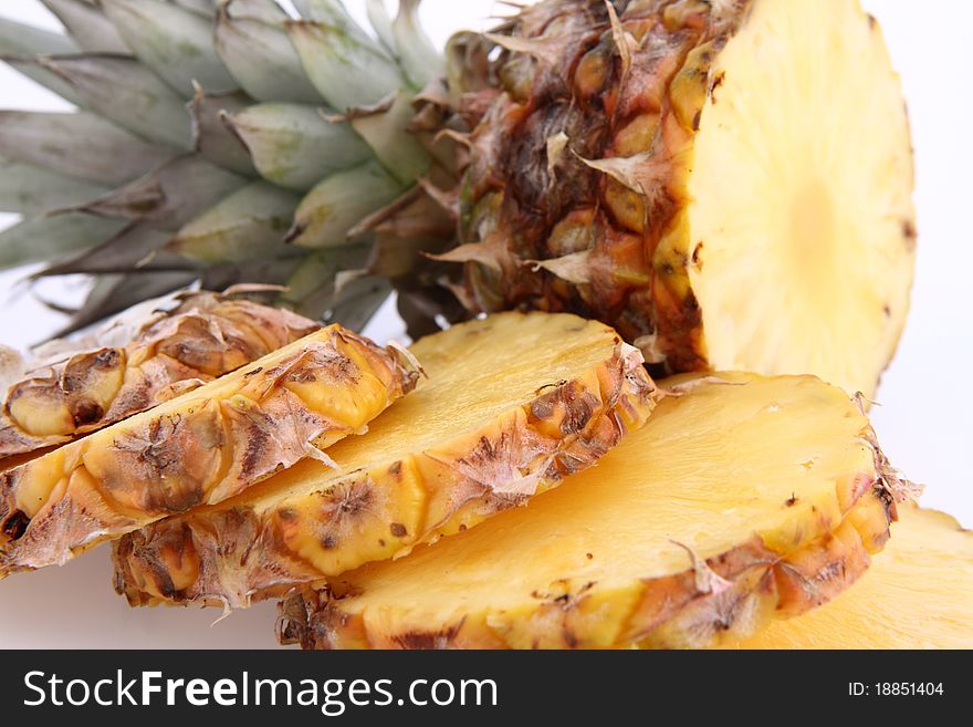 Pineapple - partially cut into slices, on white background